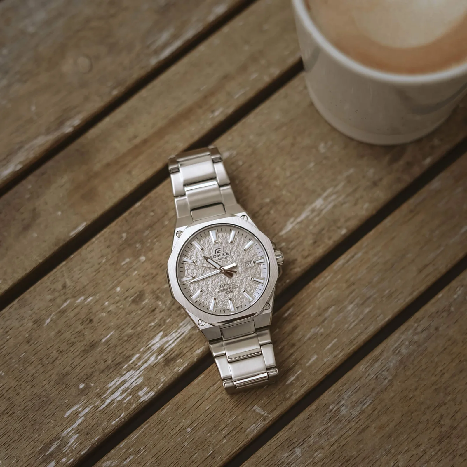 Die EFR-S108DE-8AVUEF liegt auf einem Untergrund aus Holz, eine Kaffeetasse steht daneben
