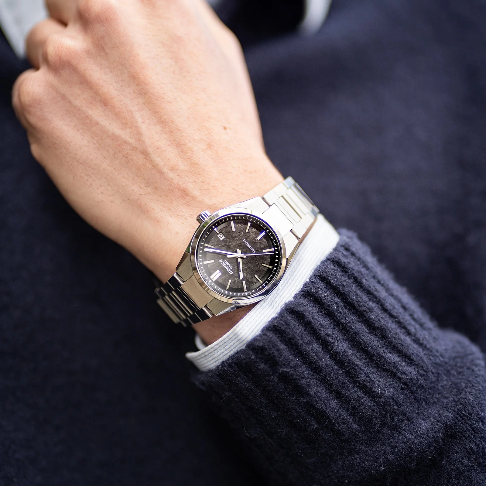 Ein Mann mit einem dunkelblauen Wollpullover trägt die mechanische EDIFICE EFK-110D-1A am Handgelenk