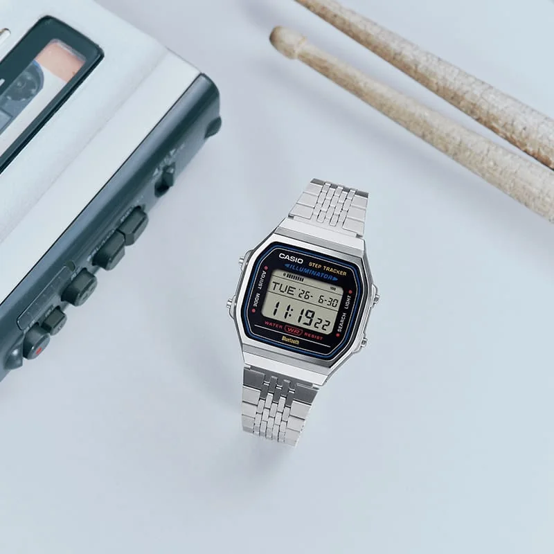 Die Uhr ABL-100WE-1A mit Schlagzeugstöcken und Audiogeräten platziert.