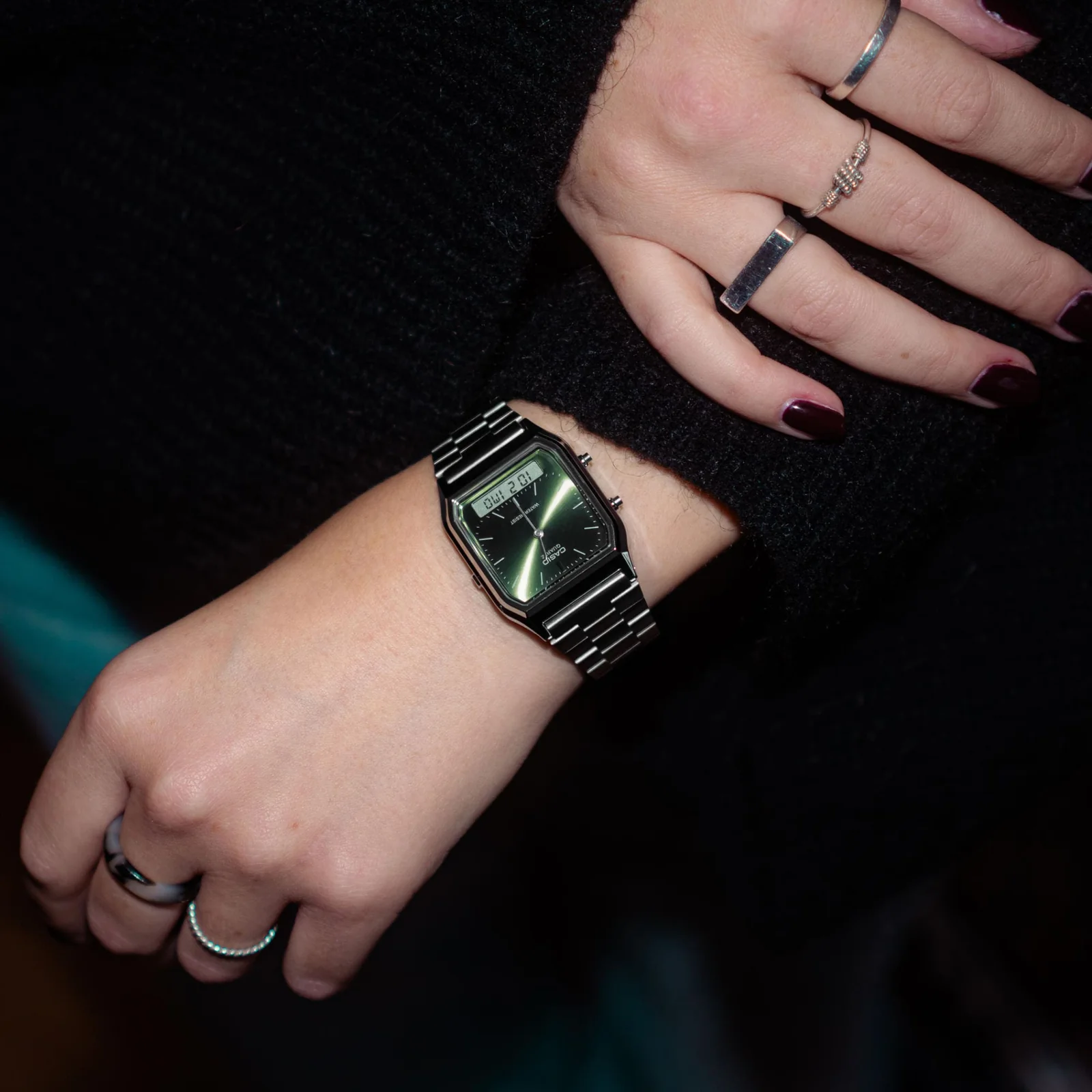 Close-Up auf das Handgelenk einer Frau, die ein schwarzes Kleid trägt. Am Handgelenk ist die AQ-230A-3AMQYES von CASIO Vintage Collection zu sehen.