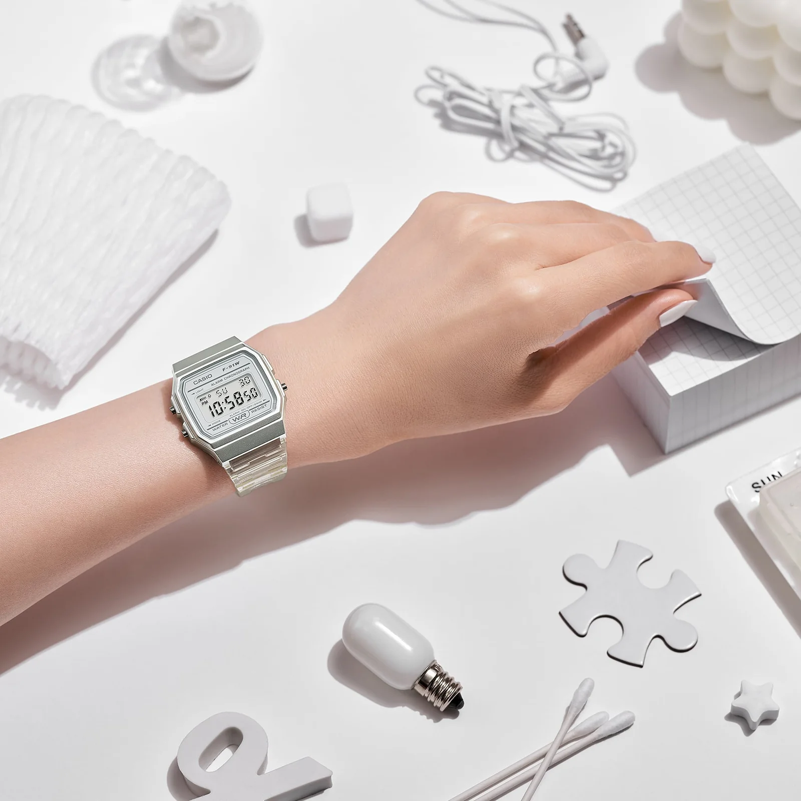 Die CASIO TIMELESS COLLECTION Armbanduhr F-91WS-7 am Handgelenk einer Person in einem Innenraum.