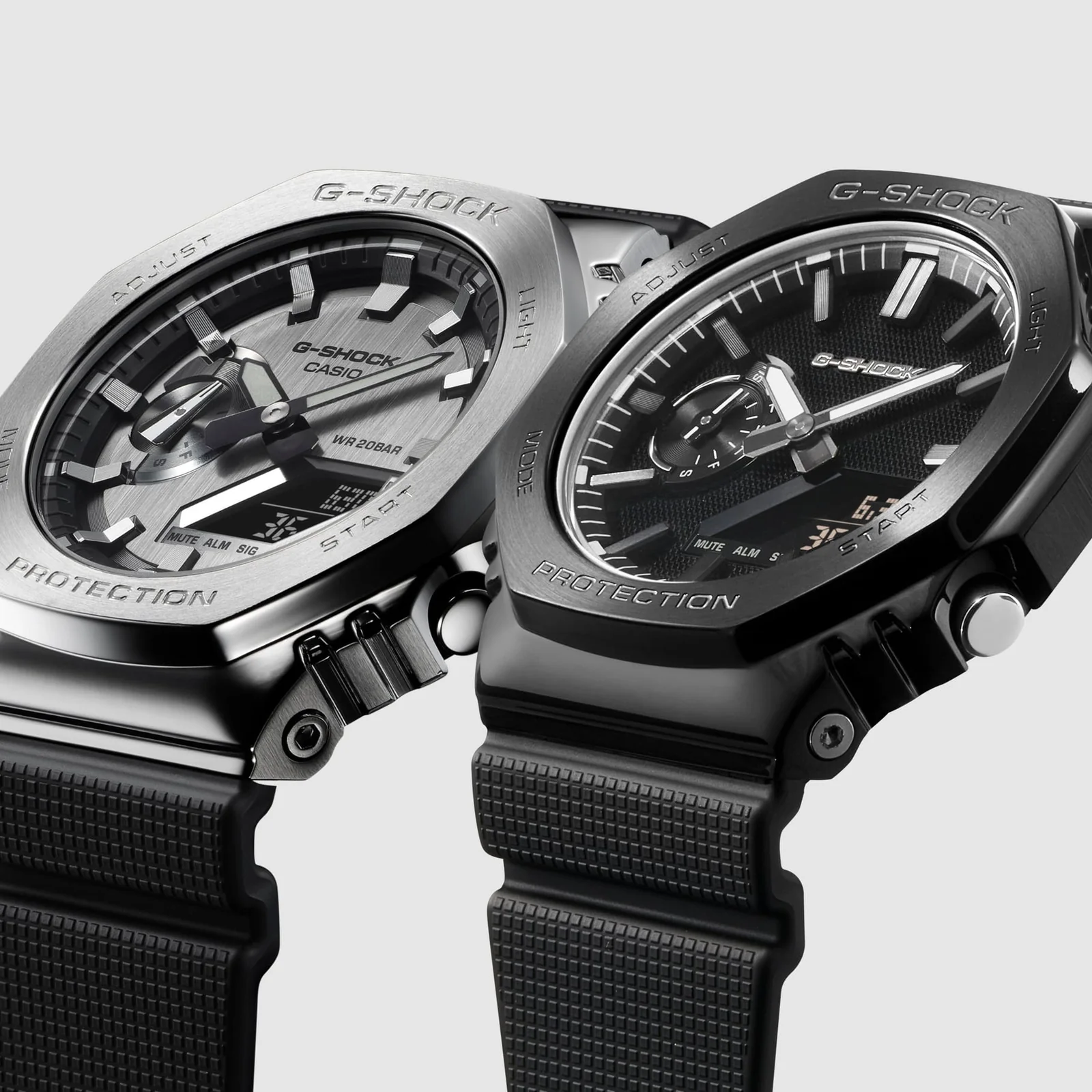 Das G-SHOCK Modell GM-2100-1A mit silbernem Gehäuse ist neben dem komplett schwarzen Modell GM-2100LXB-1A abgebildet