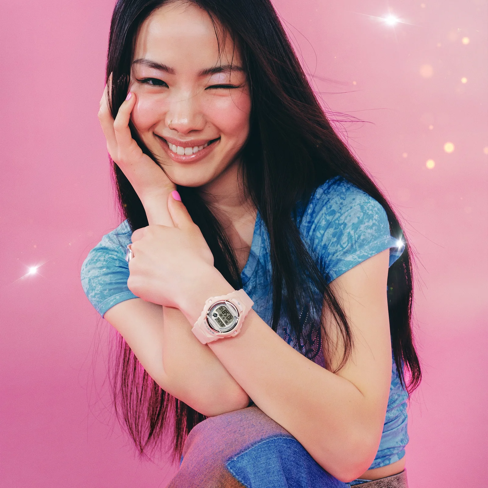 Eine Frau mit einem blauen T-Shirt und pinken Fingernägeln trägt die Armbanduhr BG-169KB-4ER am Handgelenk