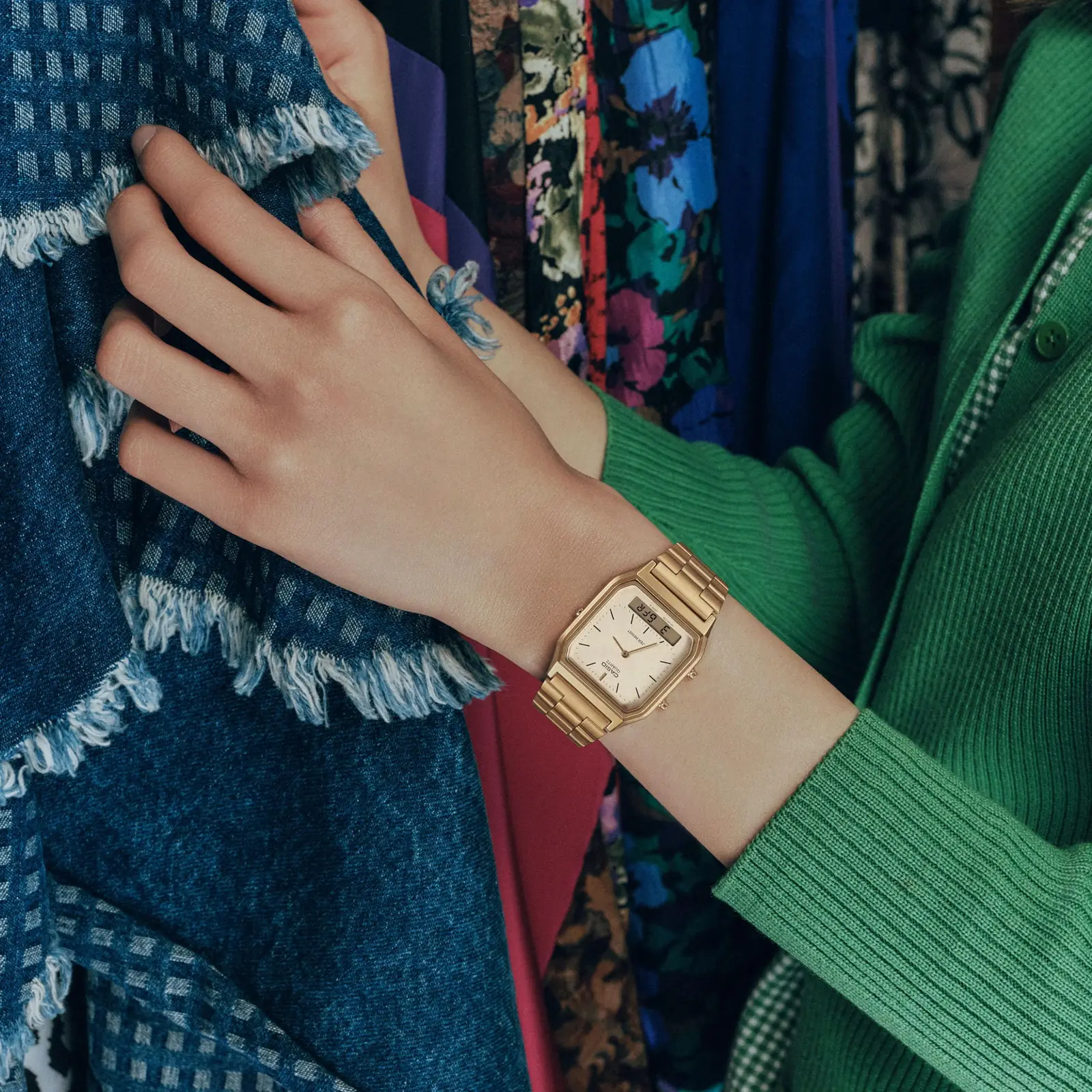 Die CASIO Vintage Collection Uhr "AQ-230A-7AMQY" mit goldenem Band und Analoganzeige am Damenhandgelenk sucht nach Kleidung.