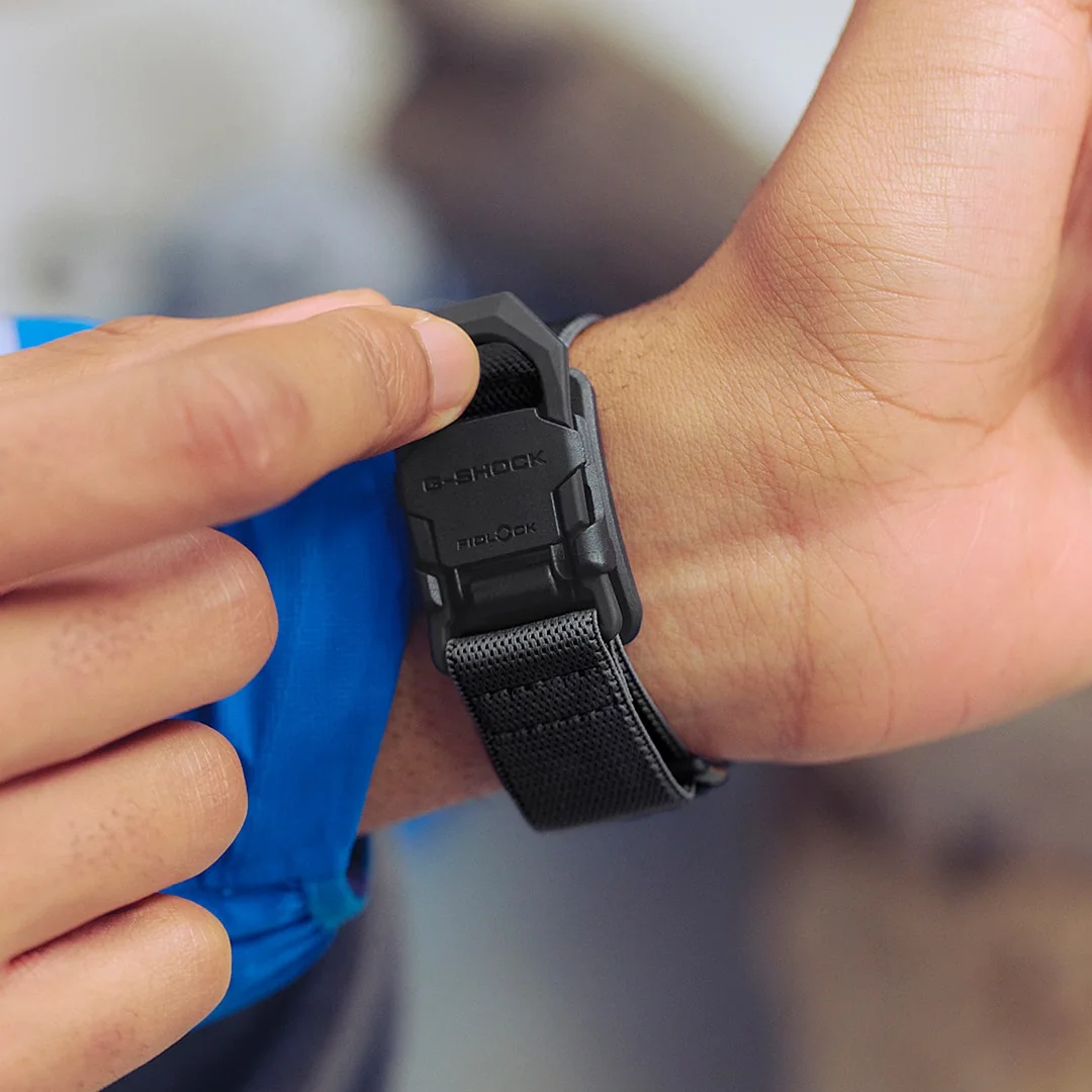 Ein Mann trägt die Digitaluhr DW-5600MNC-1ER am Handgelenk und schließt die FIDLOCK®-Magnetschließe mit einer Hand