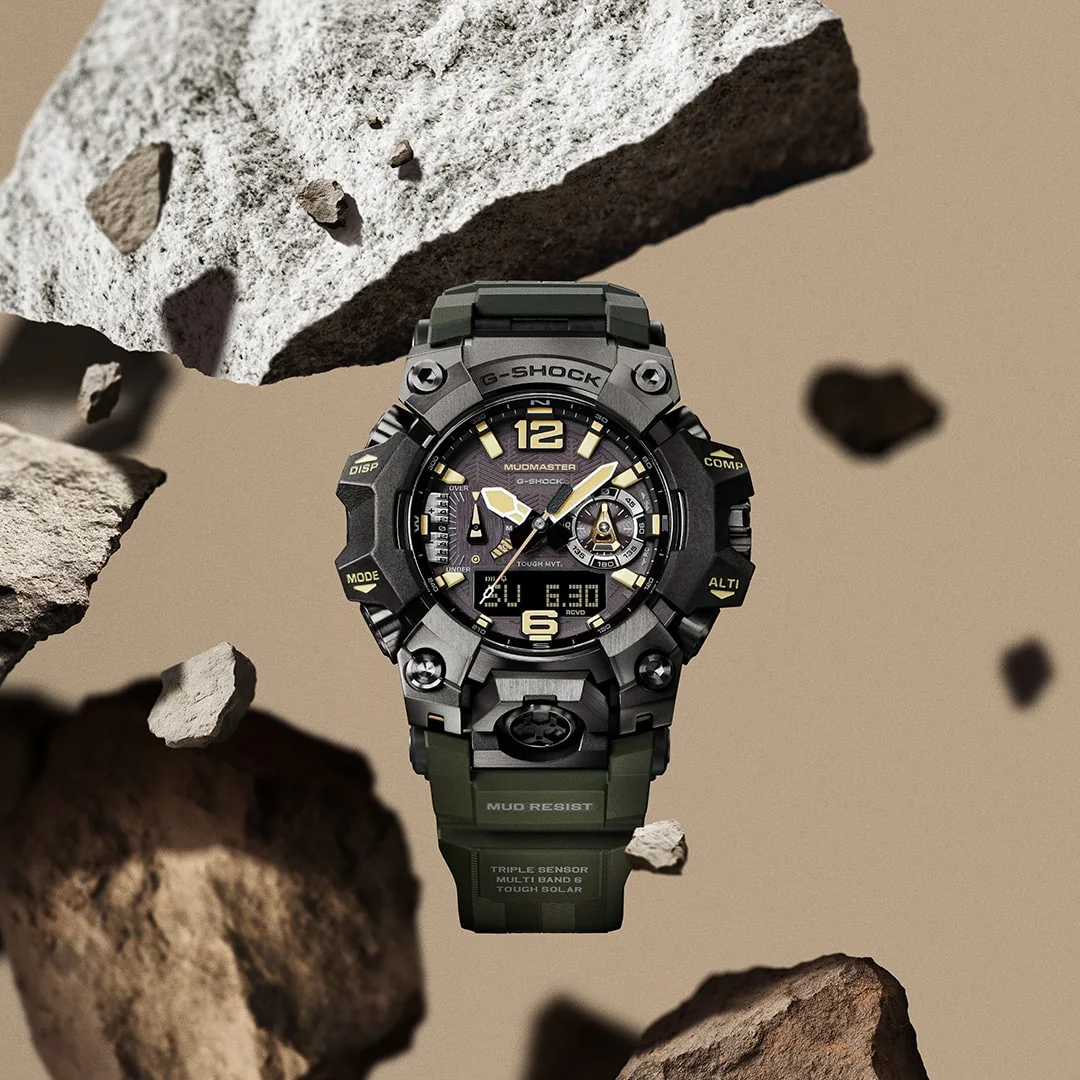 Die MUDMASTER Armbanduhr GWG-B1000-1A3 wird von Gesteinsbrocken umschwebt