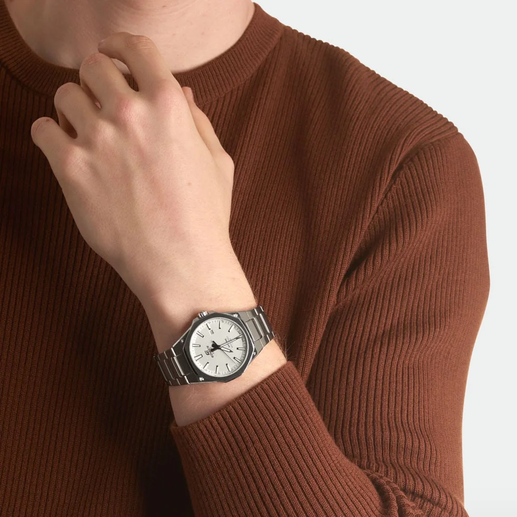 Die EDIFICE Armbanduhr EFR-S108D-7AVU am Handgelenk einer Person in einem Innenraum.