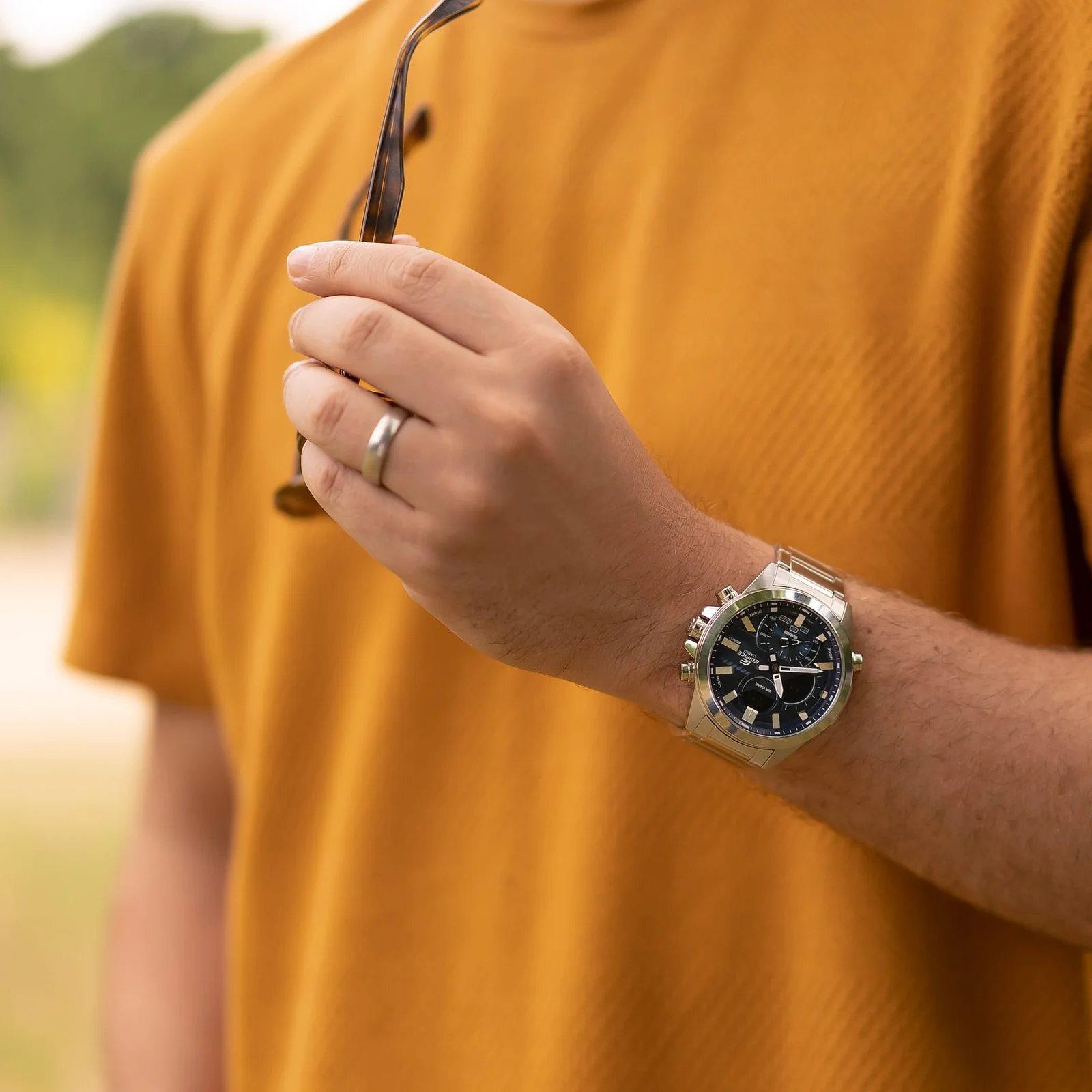 Die EDIFICE Armbanduhr ECB-30D-2A am Handgelenk einer Person in Außenumgebung.