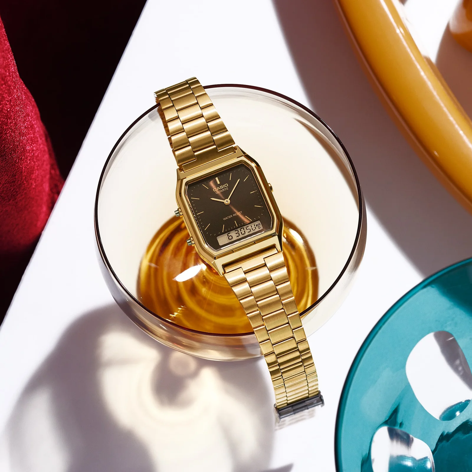 Die goldene Armbanduhr AQ-230GA-5AMYES liegt auf dem Rand eines Kaffeeglases