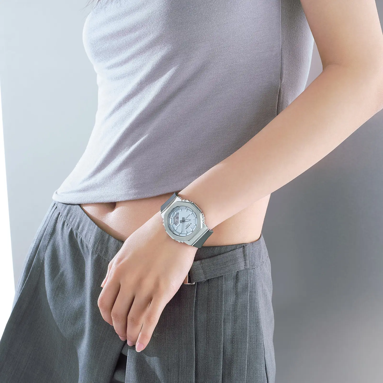 Die G-SHOCK WOMEN Armbanduhr GM-S2110-2A am Handgelenk einer Person in einem Innenraum.