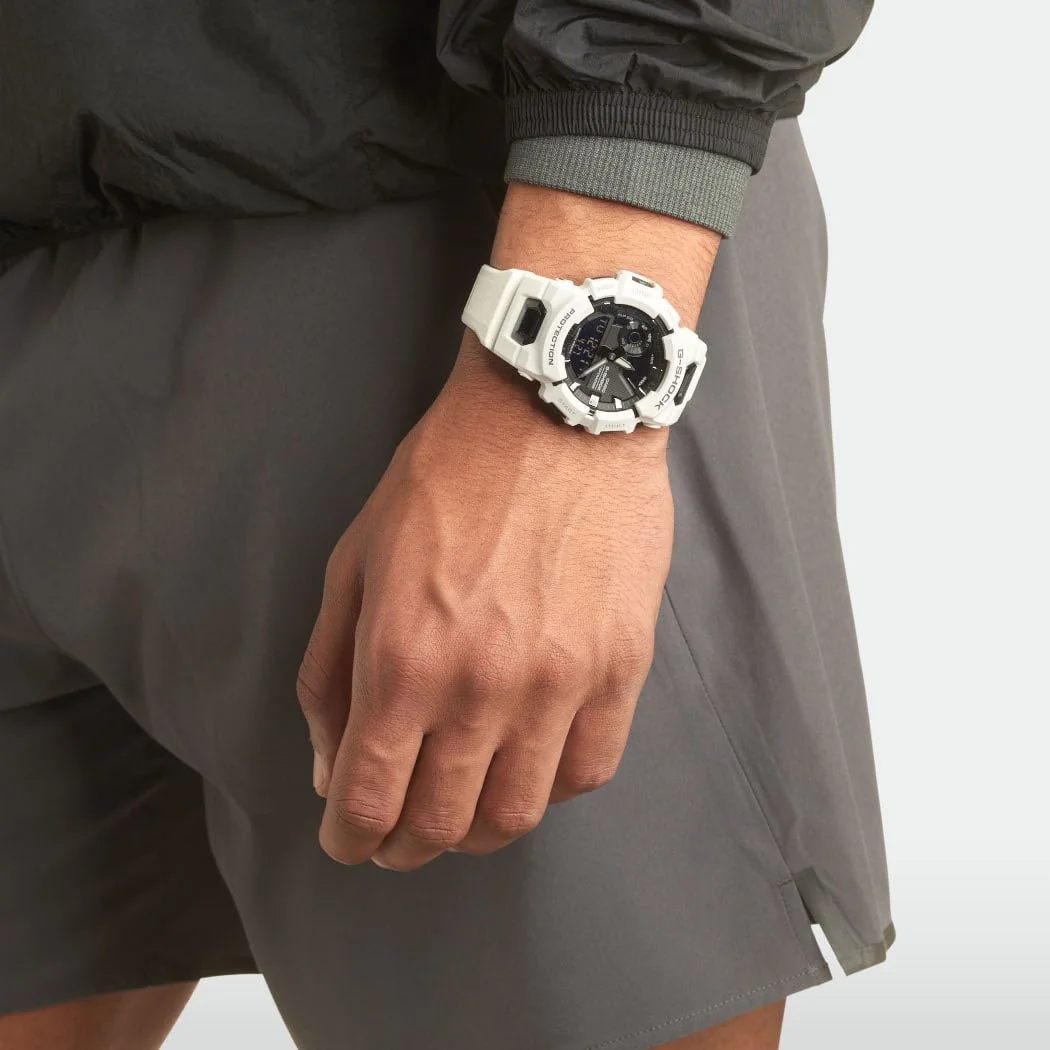 Die G-SHOCK Armbanduhr GBA-900-7A am Handgelenk einer Person in einem Innenraum.