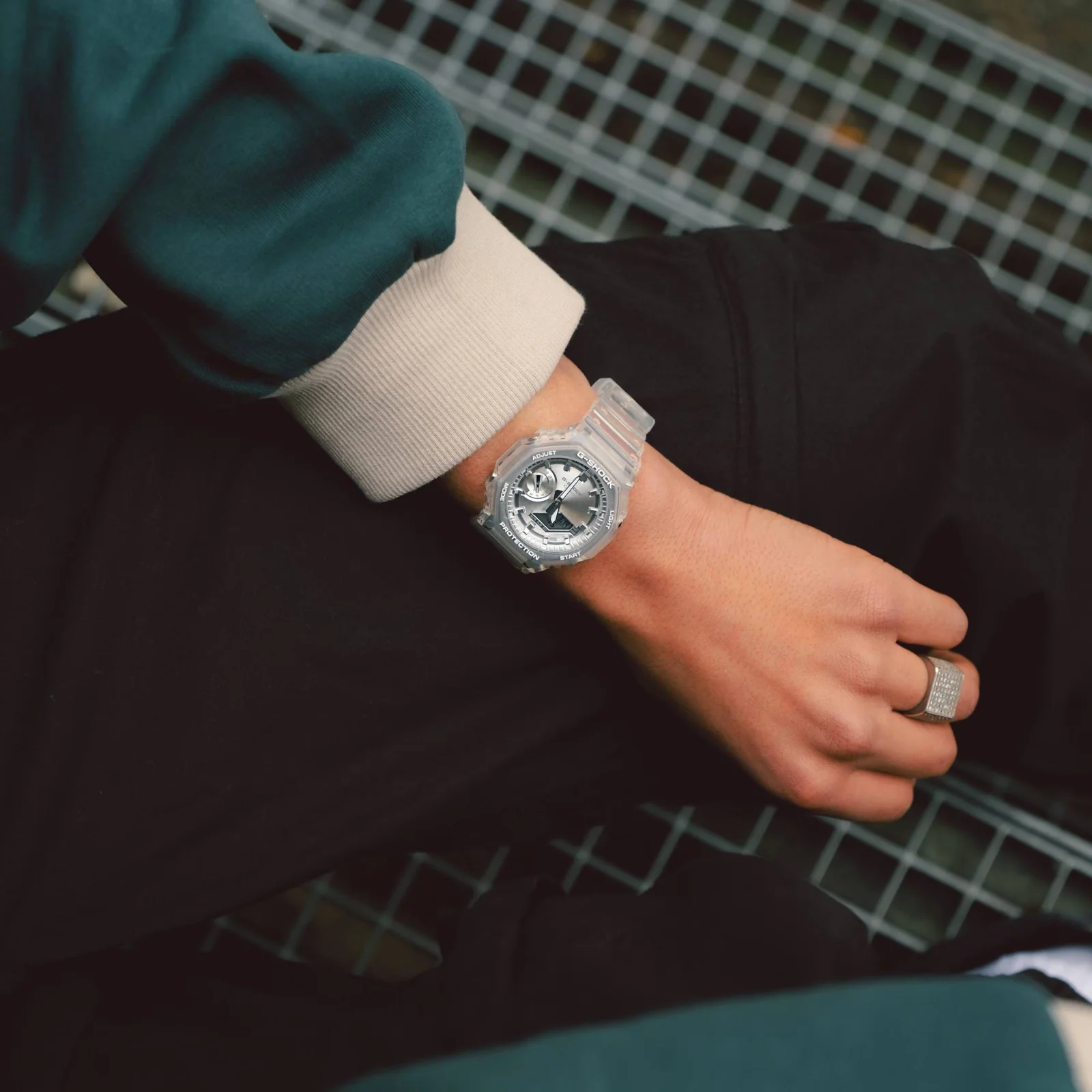 Nahaufnahme der GA-2100BM-7A8 am Handgelenk. Getragen wird die Uhr in Kombination mit einem grün-beigem Sweater.