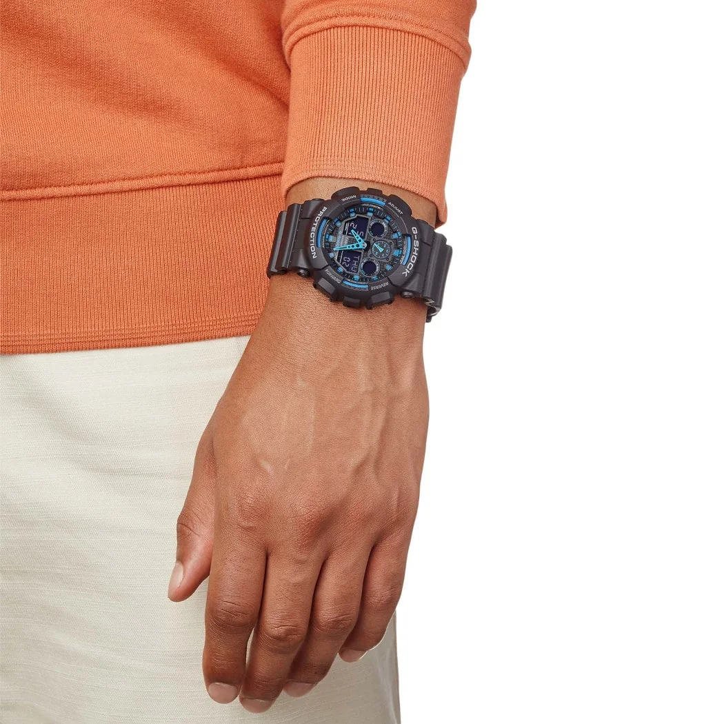Nahaufnahme der G-SHOCK Armbanduhr GA-100-1A2 am Handgelenk einer Person.