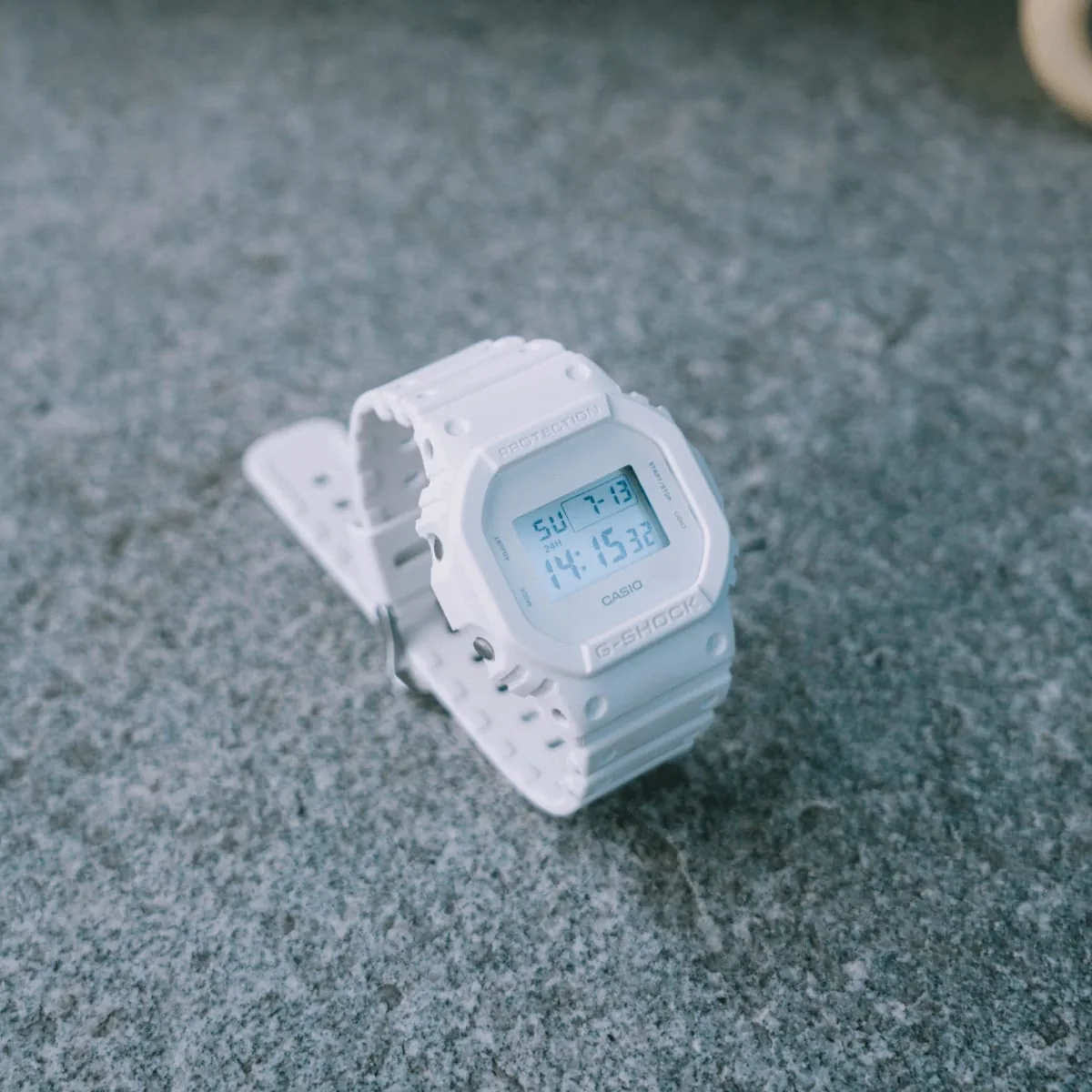 Die DW-5600WW-7 steht mit geschlossenem Armband auf einem Steinboden und ist leicht schräg von der linken Seite zu sehen