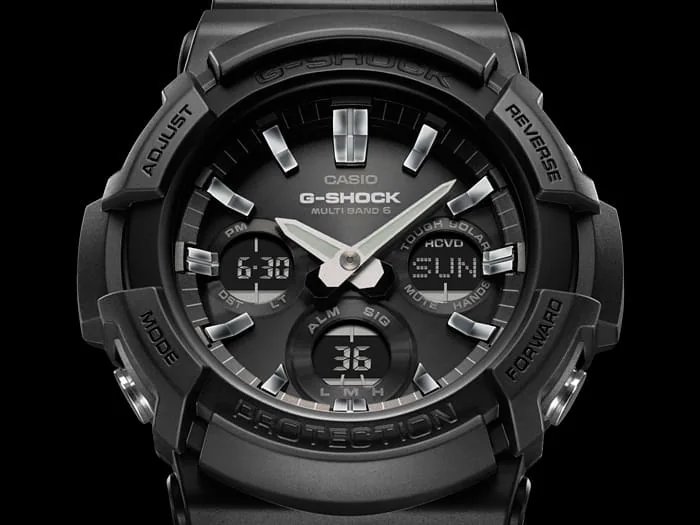 Nahaufnahme des digital-analogen Zifferblatts der G-SHOCK Armbanduhr GAW-100B-1A in Schwarz mit silberfarbenen Zeigern und Indices.