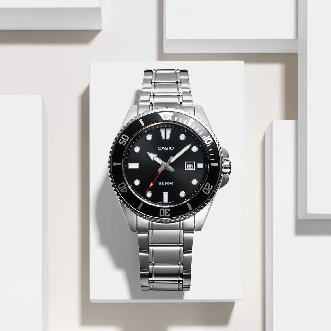 Die CASIO TIMELESS COLLECTION Armbanduhr MDV-107D-1A1V von vorn, platziert vor dekorativen Blöcken in Weiß.
