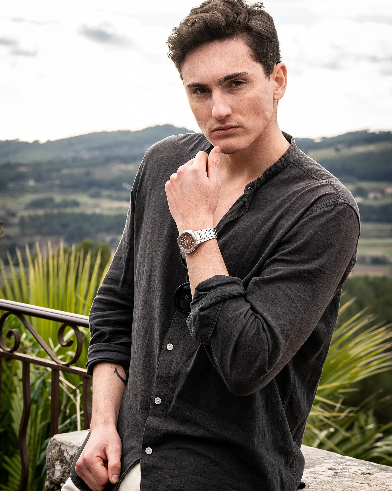 Ein Mann steht im Außenbereich und trägt die silberne Armbanduhr EFK-200D-4AER mit rundem Gehäuse am Handgelenk
