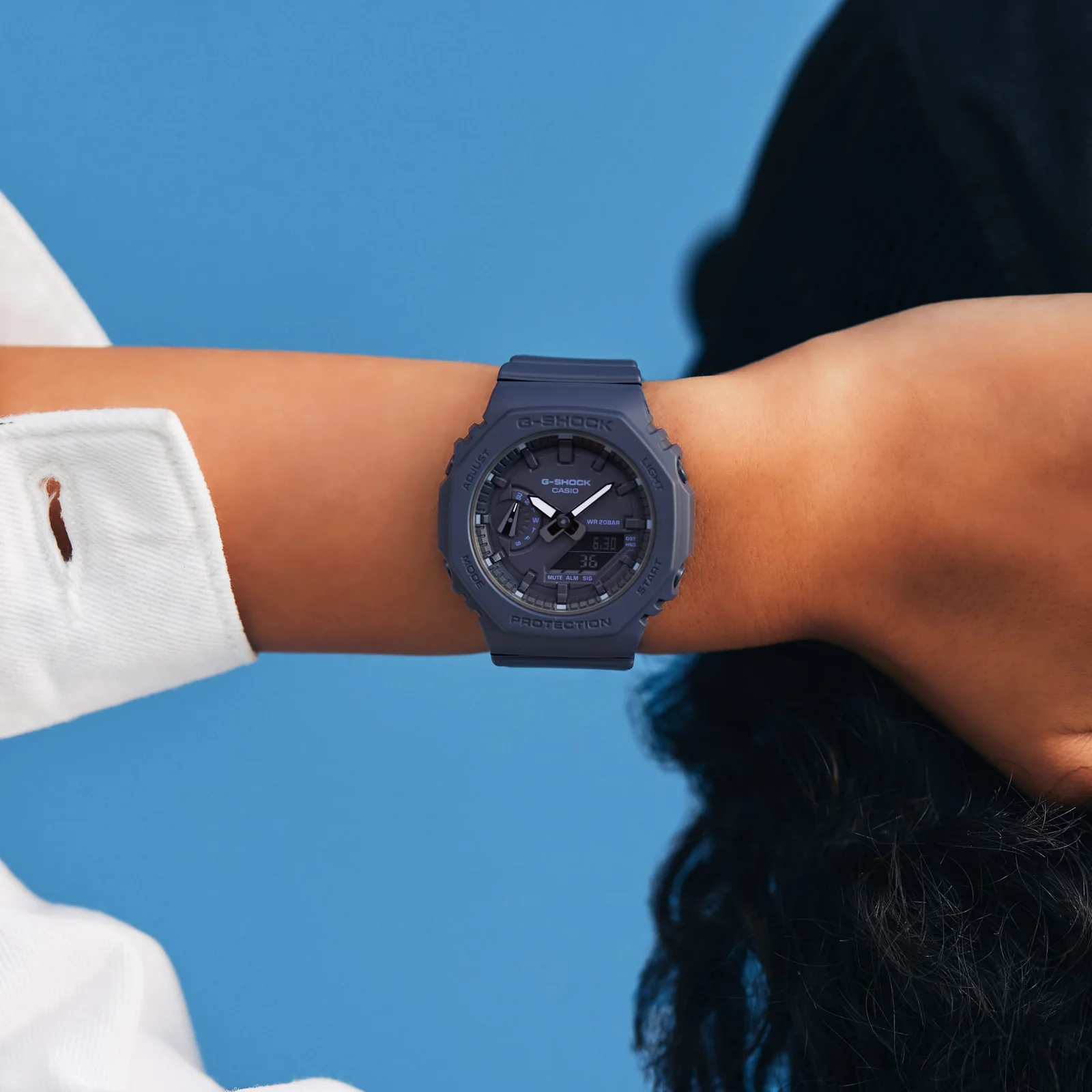 Nahaufnahme der G-SHOCK WOMEN Armbanduhr GMA-S2100BA-2A1 am Handgelenk einer Person.