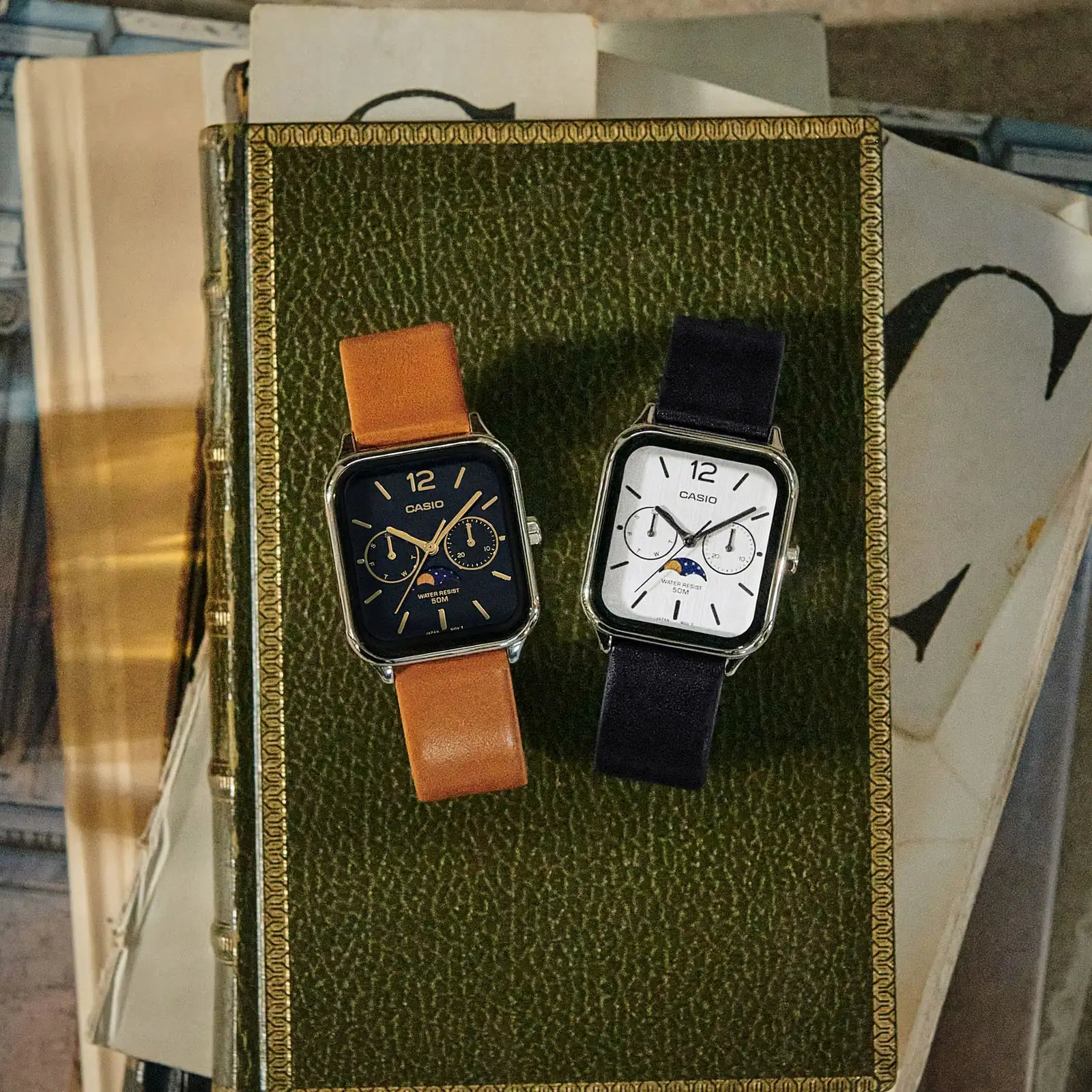 Die CASIO TIMELESS COLLECTION Armbanduhr MTP-M305L-1AV neben dem ähnlichen Modell MTP-M305L-7AV mit weißem Zifferblatt und schwarzem Armband.